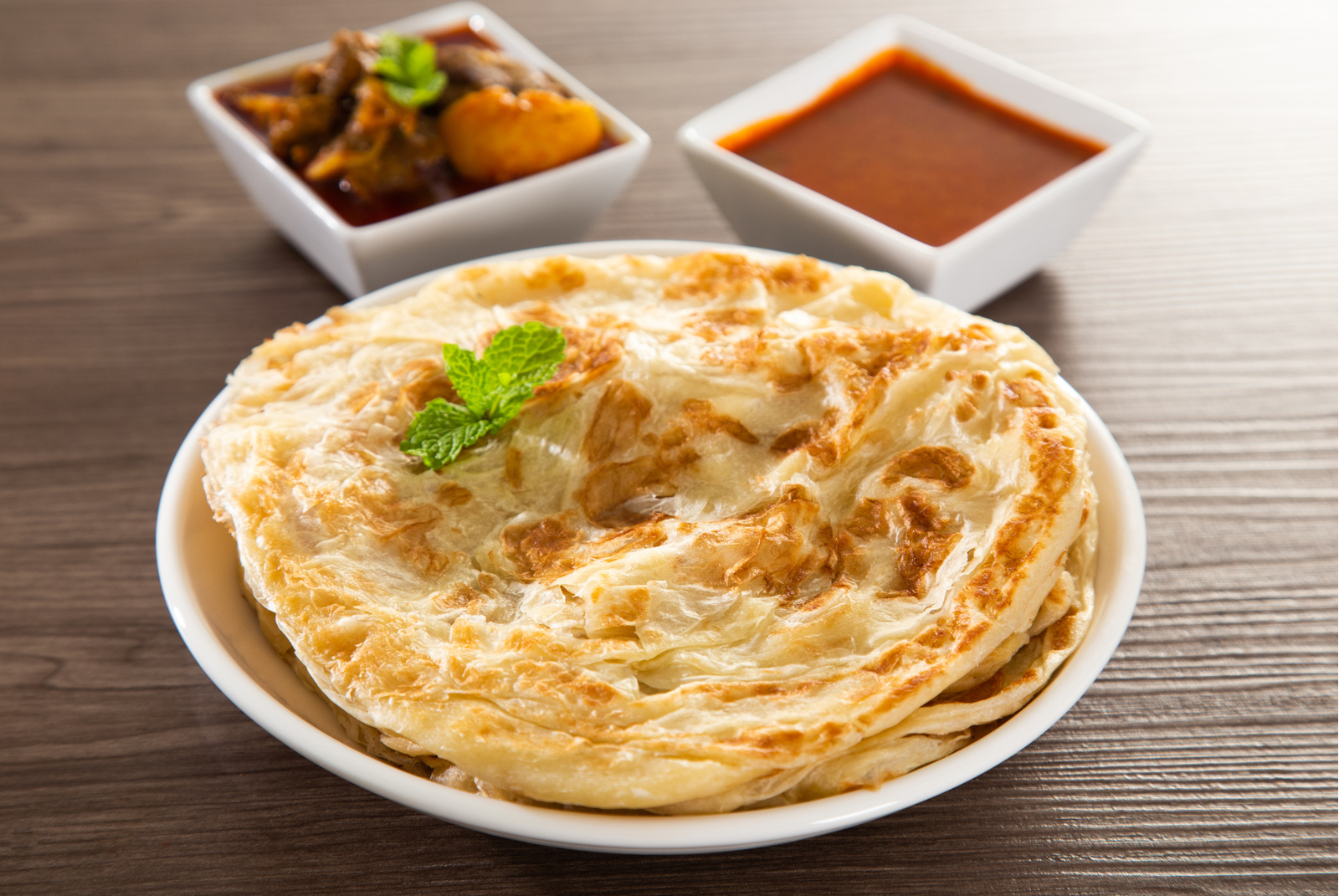 Roti canai served with dhal and curry