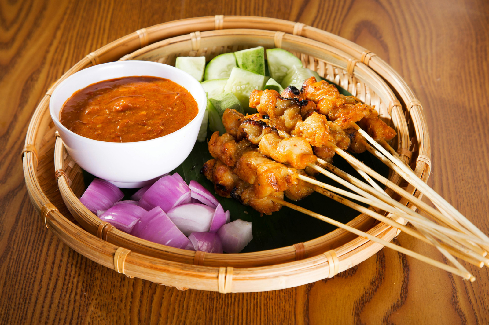 Satay skewers with peanut sauce, cucumber and onions